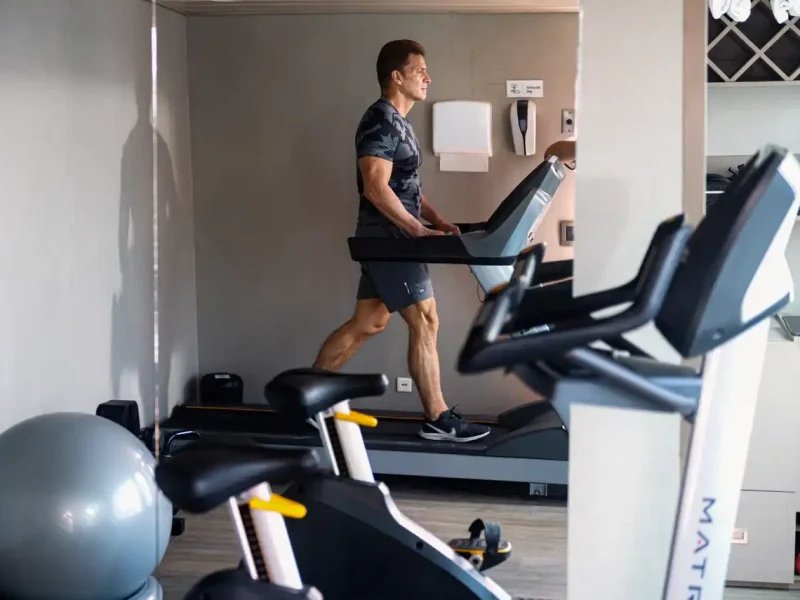 A guest using the treadmill in the fitness room aboard La Pinta