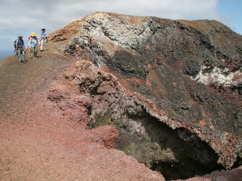 Hikers on the rim of a volcanic fissure at Sierra Negra, Isabela Island